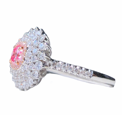 A picture  of a pink diamond quadruple halo ring with white diamonds, crafted in 18K white gold, shown from the side.